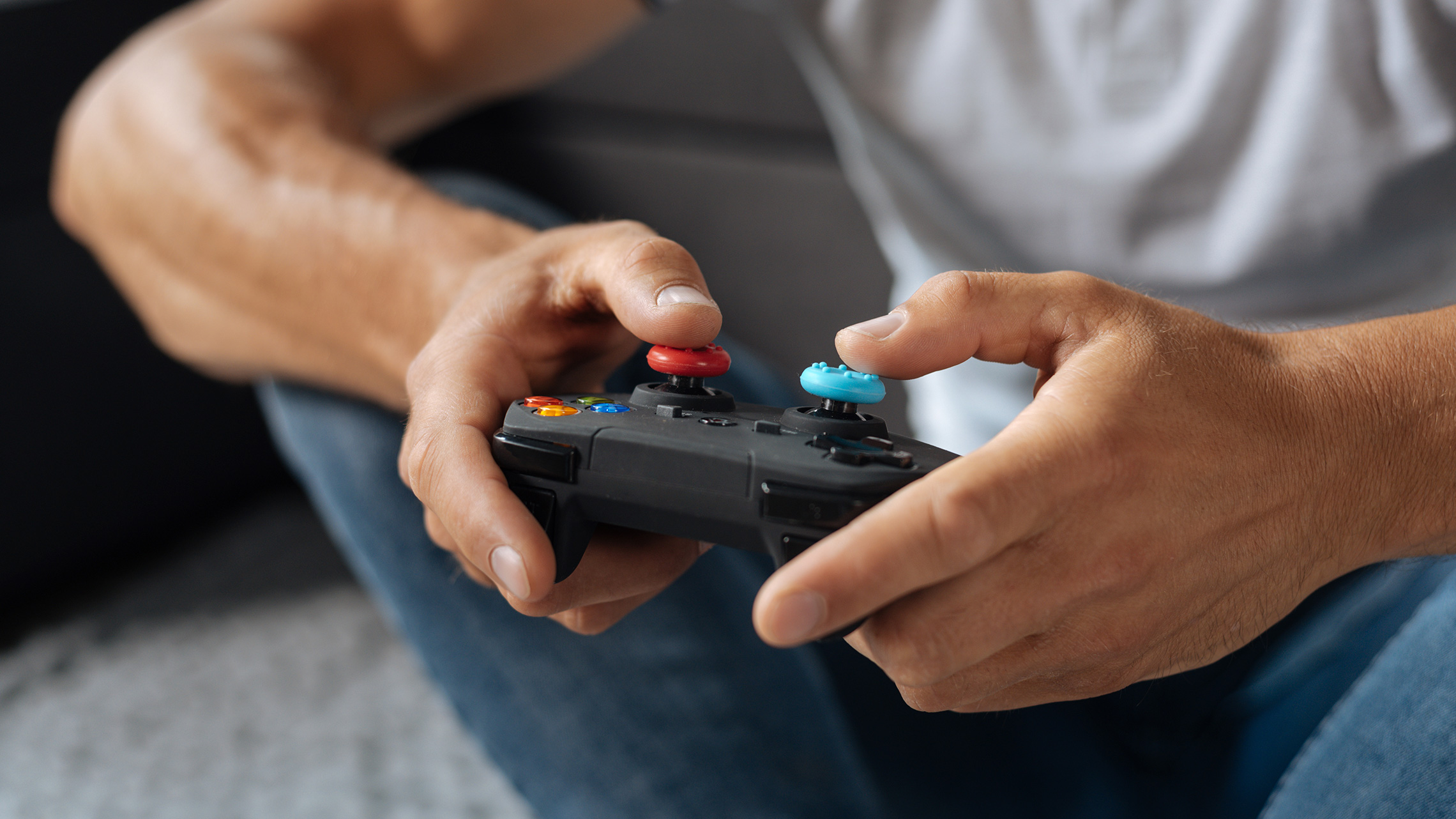 Мужчина играет в консоль фото. Man playing Portable cgame Console stock image. Мужчина играет в приставку боком. Prvita playing Console in hands.